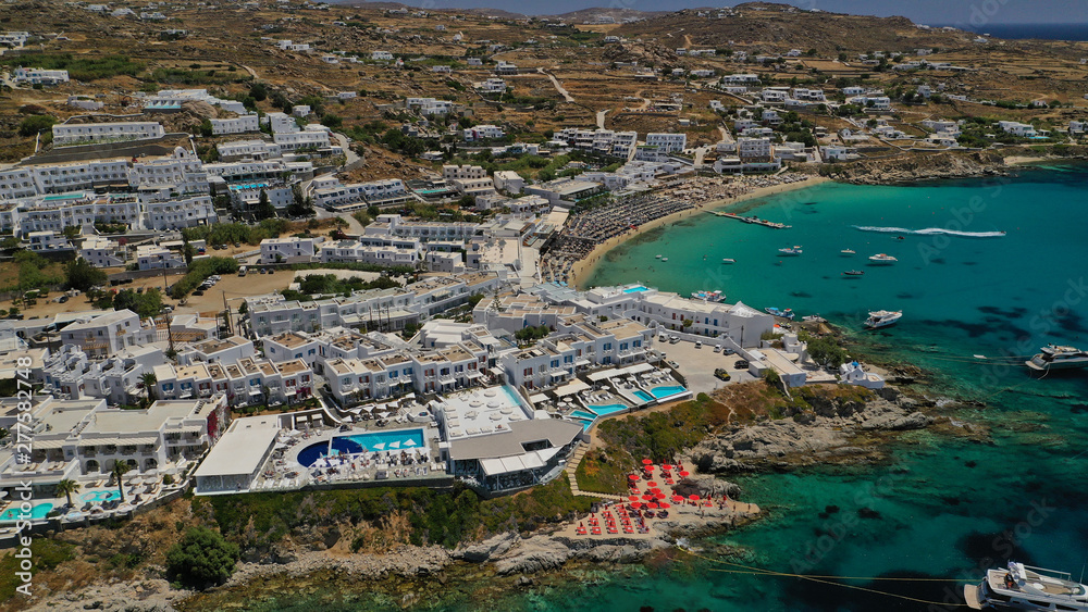 Obraz premium Aerial panoramic photo of famous turquoise clear sea celebrity sandy beach and bay of Psarou with yachts and sail boats in iconic island of Mykonos, Cyclades, Greece