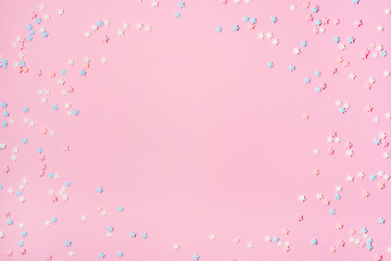 Little stars confetti on pink background. Holyday concept. Copy space for your text.