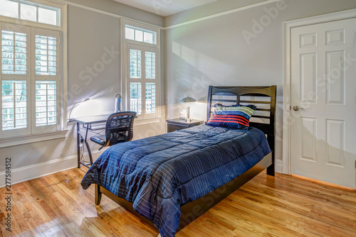 Simple guest bedroom with single bed and windows.