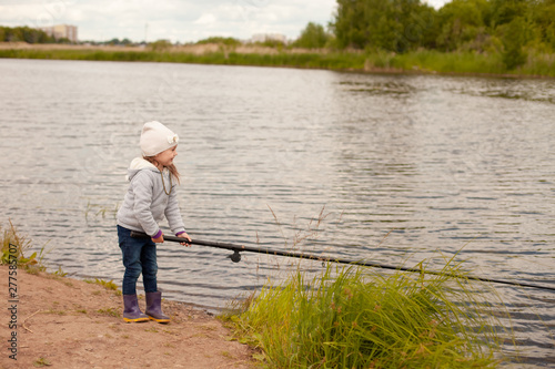 Cheerful girl fishing at the lake
