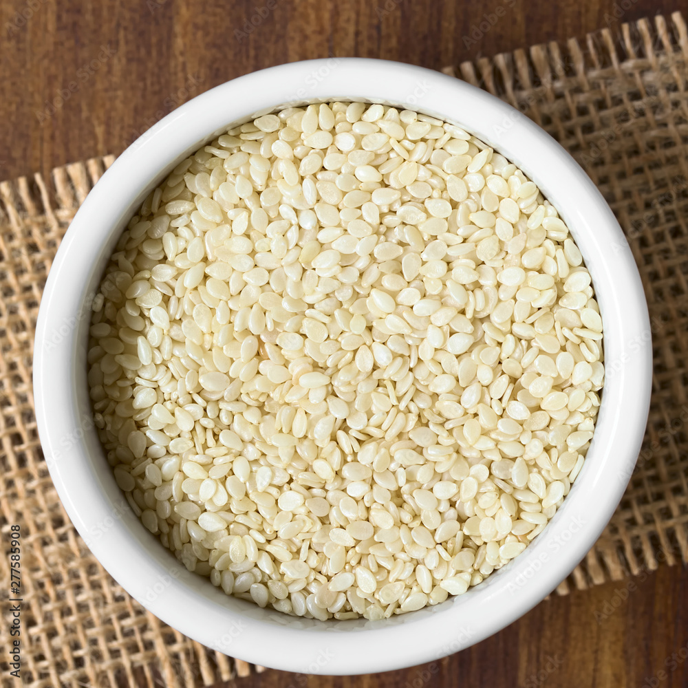 White sesame seeds in small bowl, photographed overhead with natural light (Selective Focus, Focus on the seeds on the top)
