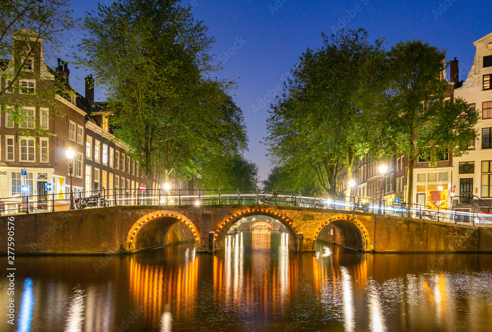 Illuminated Bridge in Amsterdam Canal at night
