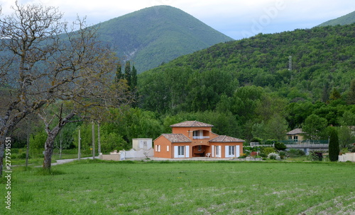 Big typical house with beautiful mountain landscape of Provence at the background, France