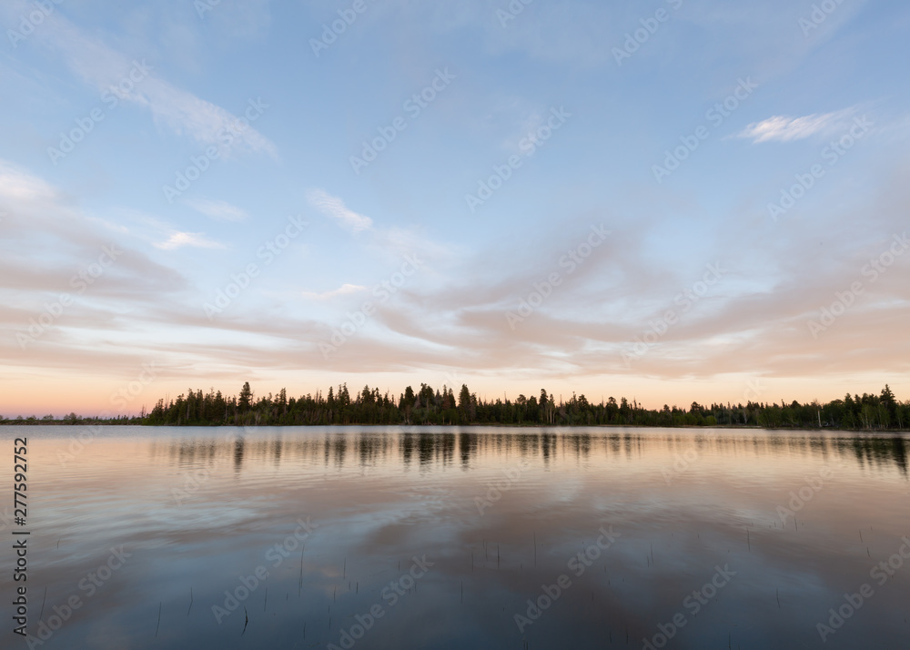 Sunset behind the camera painted the eastern horizon with soft pastel hues that are reflected in the still water of the lake. 