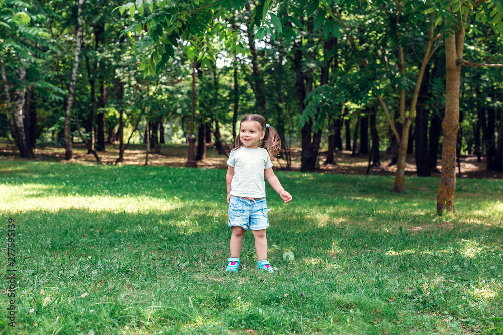 Cute little girl playing in park in summer day Cute little girl playing in park in summer day