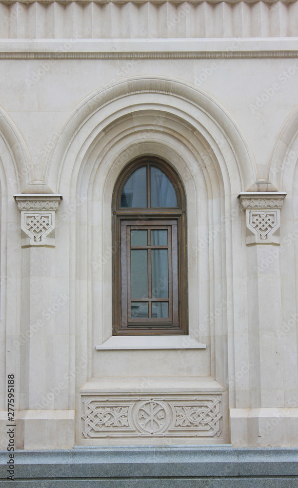Arched window frame on old house facade 