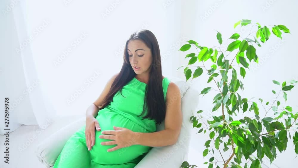 happy pregnant woman touching her tummy at home happy pregnant woman touching her tummy at home