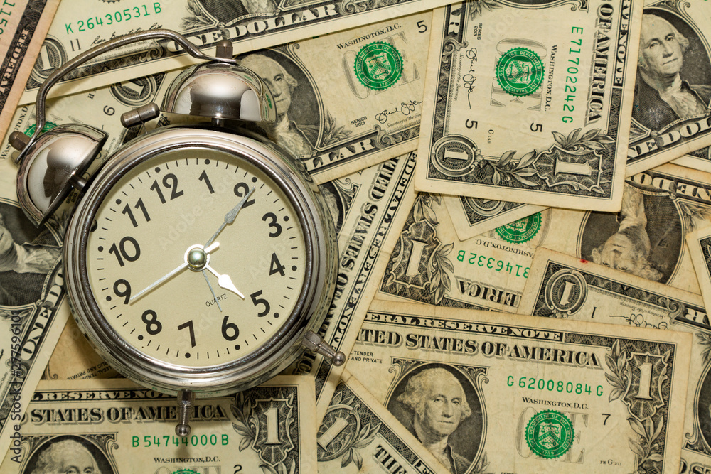 Alarm clock on carpet of dollar bills, time is money. Alarm clock on carpet of dollar bills, time is money.