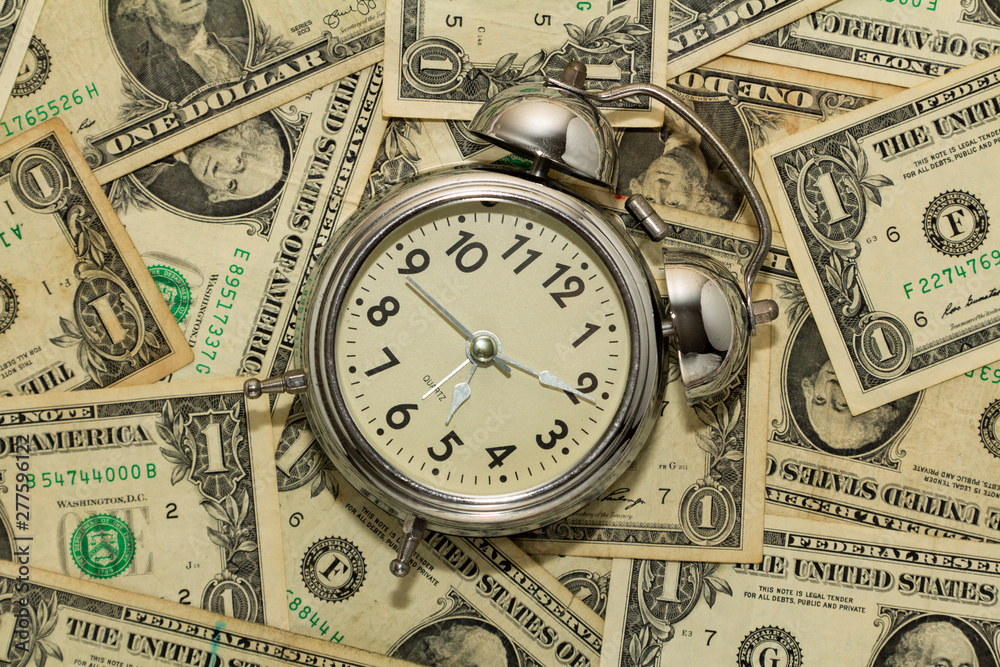 Alarm clock on carpet of dollar bills, time is money. Alarm clock on carpet of dollar bills, time is money.