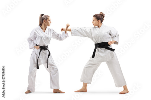 Two females in kimonos practicing karate