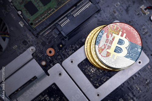 golden bitcoins with flag of serbia on a computer electronic circuit board. bitcoin mining concept. photo