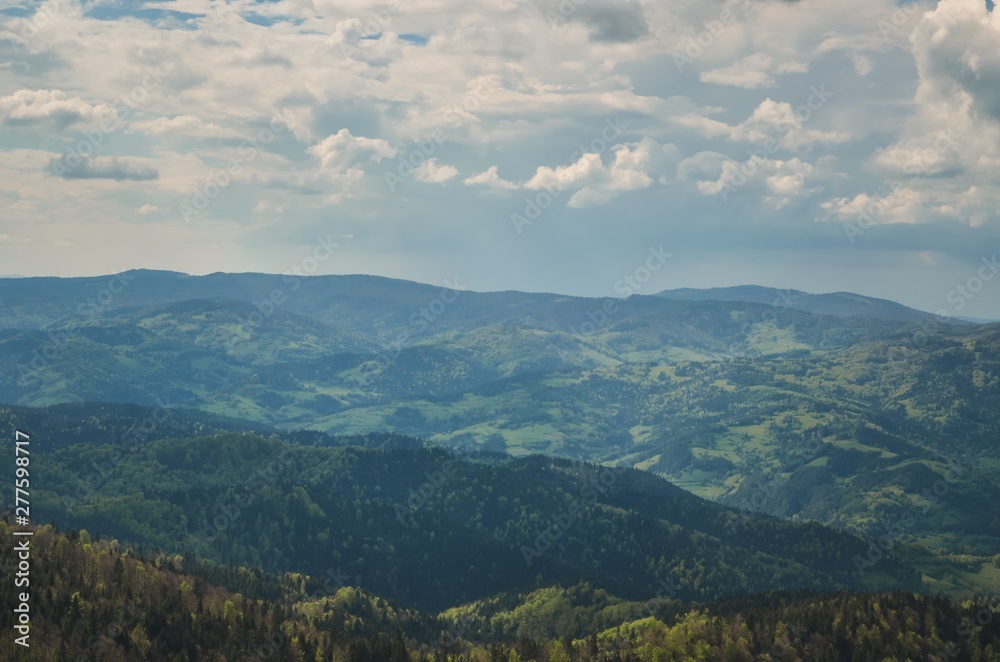 Amazing spring mountain landscape. Shadows and lights on the trees in the hills.