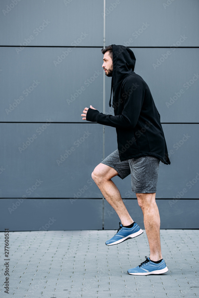 side view of handsome sportsman in starting position ready to run side view of handsome sportsman in starting position ready to run