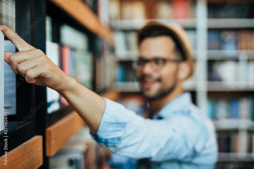 Attractive young male student choosing books in the bookstore Attractive young male student choosing books in the bookstore