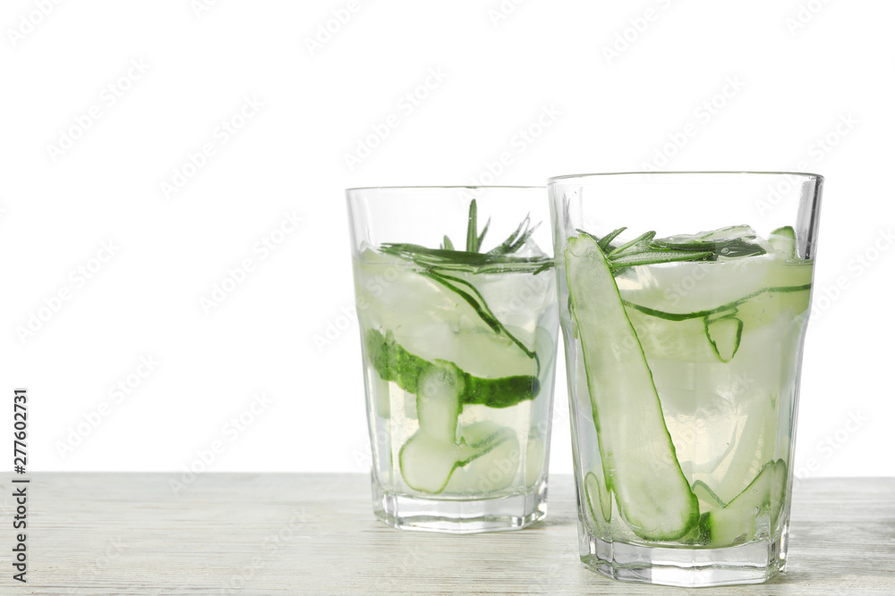 Glasses of refreshing cucumber lemonade and rosemary on wooden table against white background. Summer drink Glasses of refreshing cucumber lemonade and rosemary on wooden table against white background. Summer drink