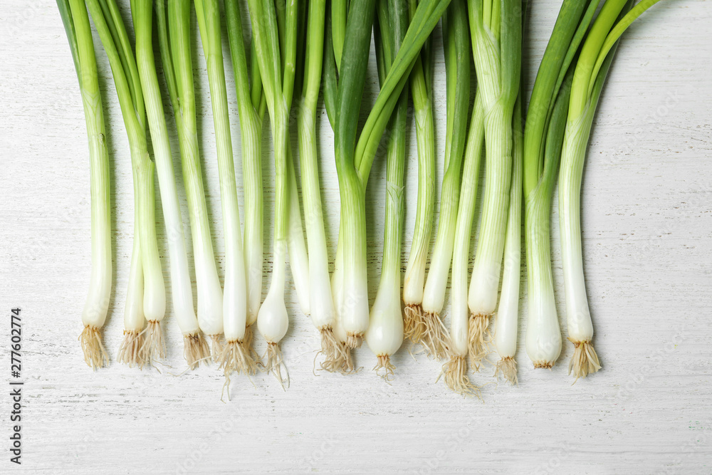 Fresh green onions on white wooden background, top view Fresh green onions on white wooden background, top view