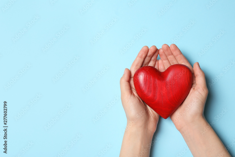 Obraz premium Woman holding heart on blue background, top view with space for text. Donation concept