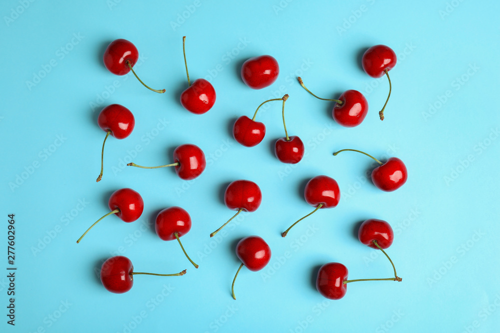 Many ripe sweet cherries on light blue background, flat lay Many ripe sweet cherries on light blue background, flat lay
