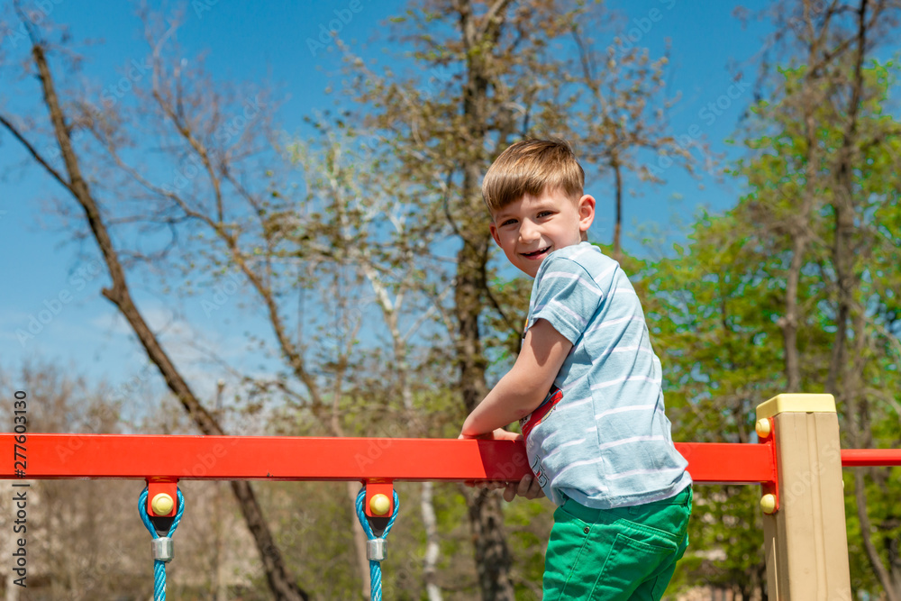 A child on the sports playground, a boy walks on the cable car in an extreme park. A child on the sports playground, a boy walks on the cable car in an extreme park.