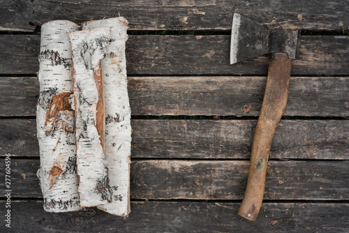 Hatchet and a wooden logs on a wooden floor background. photo