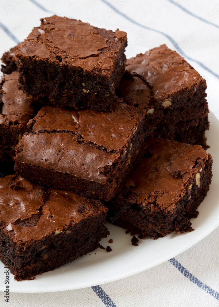 Freshly baked chocolate brownies on a white plate, side view. Closeup. Freshly baked chocolate brownies on a white plate, side view. Closeup.