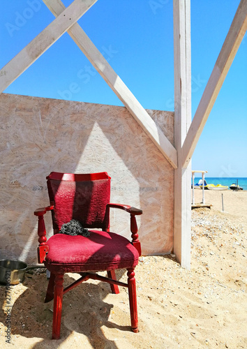 old red chair on the beach