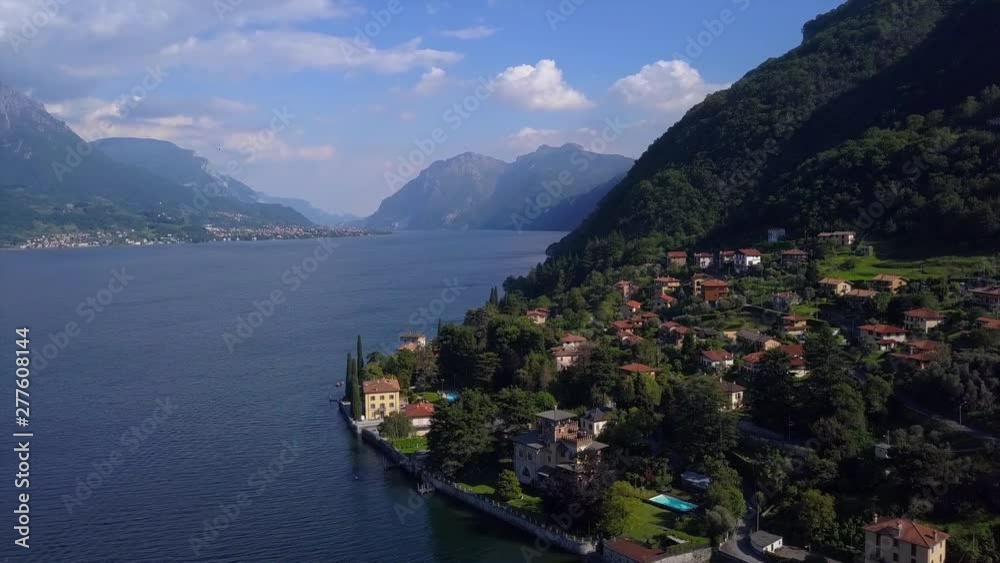 Aerial view of lakeside buildings and villas. Drone flies over small village by famous mountain lake Como in the north of Italy Aerial view of lakeside buildings and villas. Drone flies over small village by famous mountain lake Como in the north of Italy