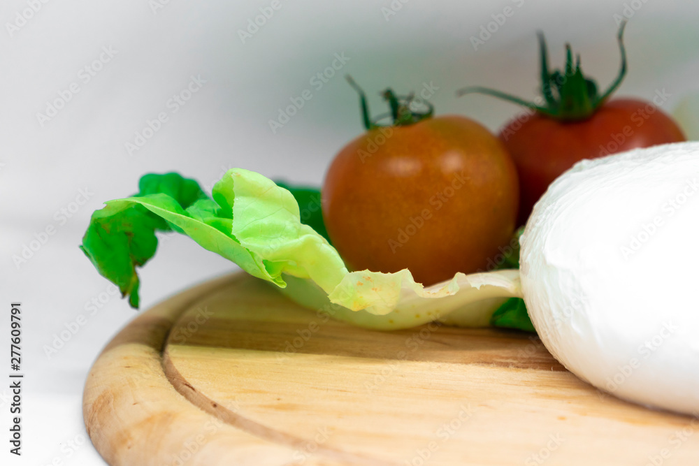Italian mozzarella with tomatoes and fresh salad on white background Italian mozzarella with tomatoes and fresh salad on white background