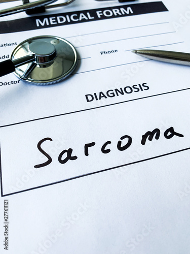 Diagnosis sarcoma in a medical form on the doctor desk photo