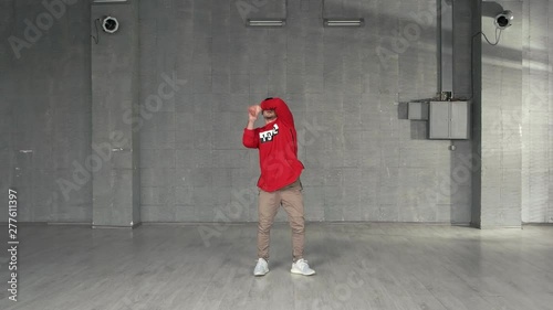 Stylish guy dancing hip-hop indoor. Young handsome guy in fashion casual clothes dancing break dance. Skillful dance performer.
