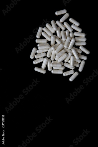 white pills on black background. medical pharmacy