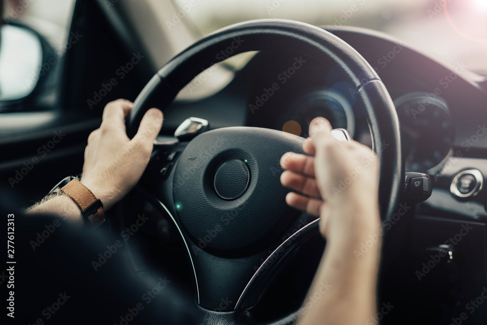 driver's hands gesticulate behind the wheel of a car