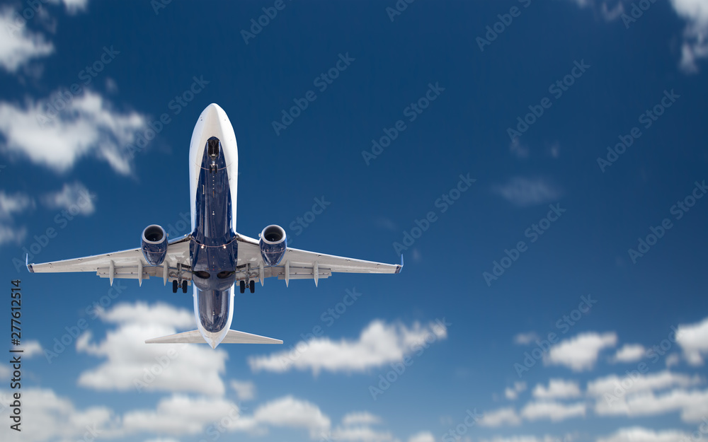 Obraz premium Bottom View of Passenger Airplane Flying In The Blue Sky