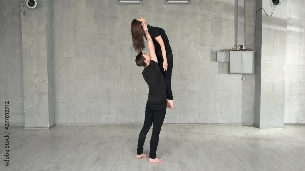 Young handsome dancer lifting up his female partner. Basic movement of performance. Sport dancing concept. Young handsome dancer lifting up his female partner. Basic movement of performance. Sport dancing concept.