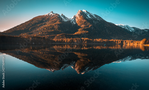 Fantastic sunrise at Hintersee lake. Beautiful scene of trees on a rock island during Spring