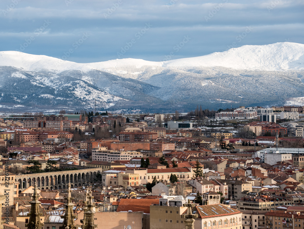 A rooftop view of Segovia, Spain with the snowy mountains in the background taken from the top of the city's cathedral. 