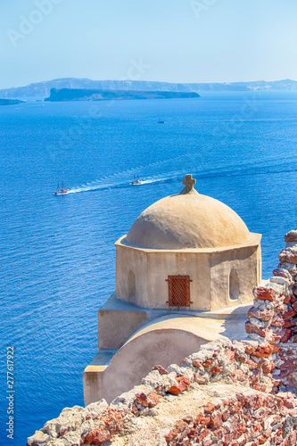 Travel Destinations. Sailing Boats Floating In Front Ancienta Pale Greek Church in Oia Village in Santorini. photo