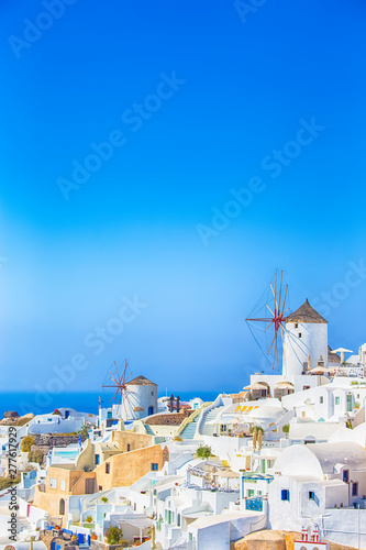 Oia Village in Santorini Island Located on Volcanic Calderra at Daytime. Traditional Windmills on Background.