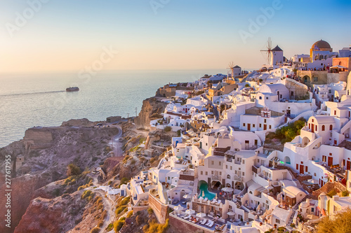 Cityscape of Oia Village in Santorini Island Located on Red Volcanic Calderra at Daytime with Ferry on Background. © danmorgan12