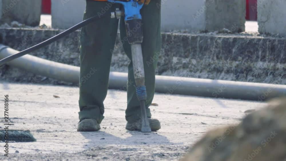 Road worker operates with jackhammer on the bridge Road worker operates with jackhammer on the bridge