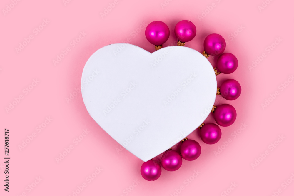 Gift box, christmas balls on pink background. Christmas gifts and decoration on white background with copy space for text. Holiday and celebration concept for postcard or invitation. Top view 