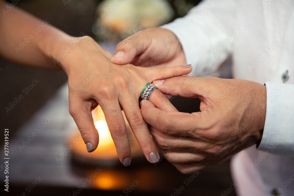 Wedding ring bride's finger. Bride and Groom´s holding hands. Wedding day concept. Marriage rings on the fingers of the newlyweds. Til death do us part. Close up.  Heterosexual couple getting married.