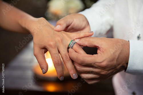 Wedding ring bride s finger. Bride and Groom  s holding hands. Wedding day concept. Marriage rings on the fingers of the newlyweds. Til death do us part. Close up.  Heterosexual couple getting married.