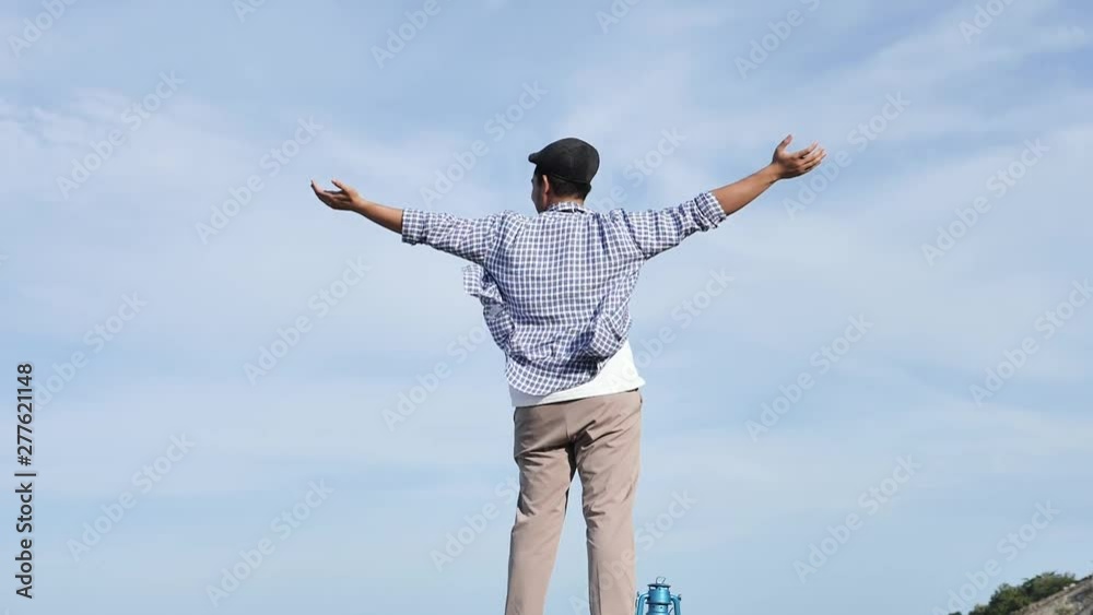 Asian man raising hands with blue sky and top mountain view, lifestyle concept. Asian man raising hands with blue sky and top mountain view, lifestyle concept.