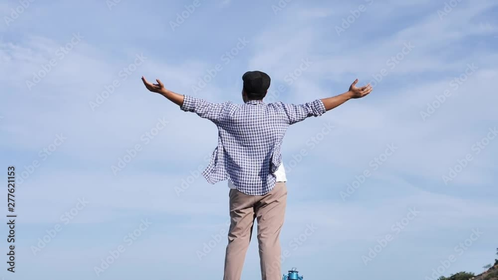 Asian man raising hands with blue sky and top mountain view, lifestyle concept. Asian man raising hands with blue sky and top mountain view, lifestyle concept.