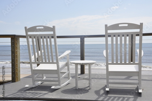 rocking chairs facing beach