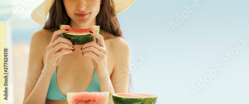 Beautiful woman eating watermelon at the beach photo