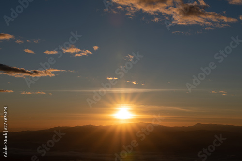 Mountain range with visible silhouettes through the morning colorful fog.