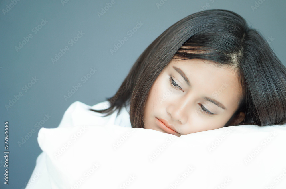 Closeup woman holding pillow sitting on bed in the bedroom with depressed feeling, selective focus Closeup woman holding pillow sitting on bed in the bedroom with depressed feeling, selective focus