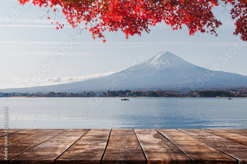 Empty wood table top on Mt Fuji in the morning lake background with red maple leaf in autumn - can used for display or montage your products.
